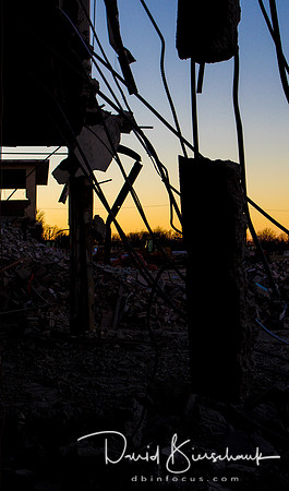 Sun setting through the broken concrete and rebar